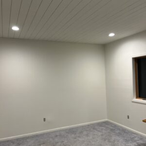 Ship lap ceiling and fresh paint and slim lights update large bedroom.