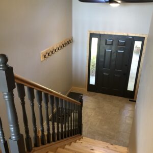 Front entry with new tile, trim, stair treads and risers, freshly painted door and spindles. (After)